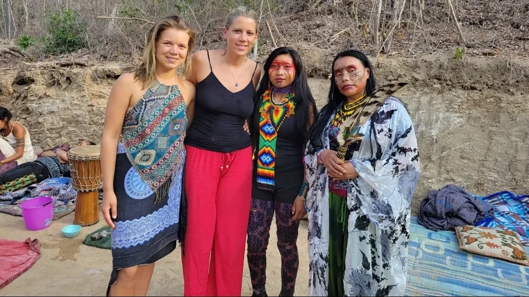 Alexandra and a friend with two Huni Kuin women in face paint and beaded collars after an ayahuasca ceremony, 2022