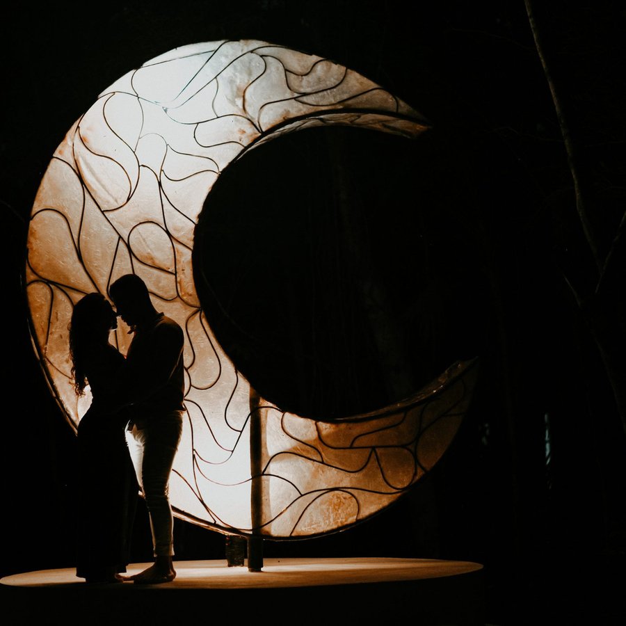 The crescent moon sculpture lit at night