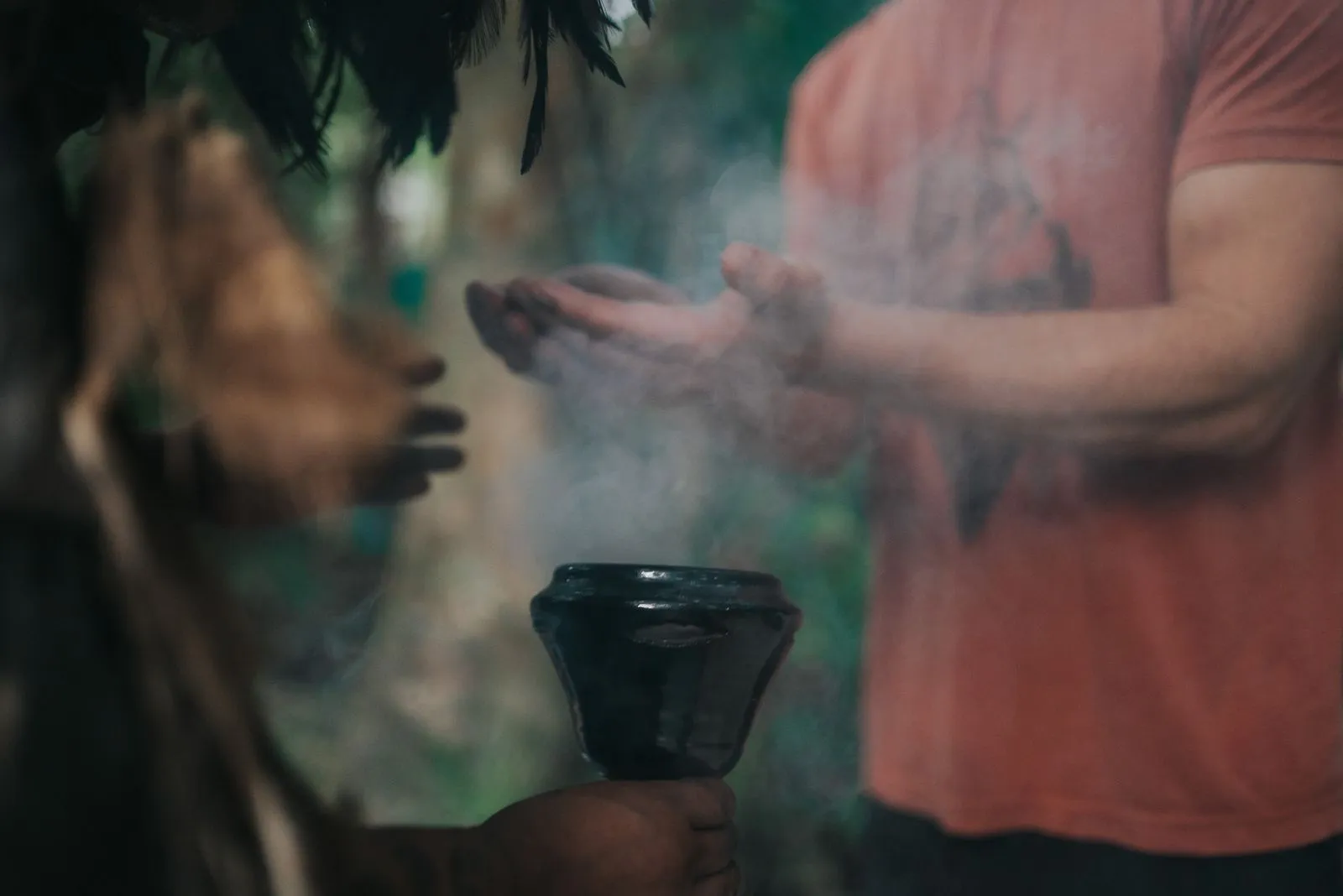 Hands pass copal smoke in a clay vessel during a clearing ritual, Lunita Jungle Retreat