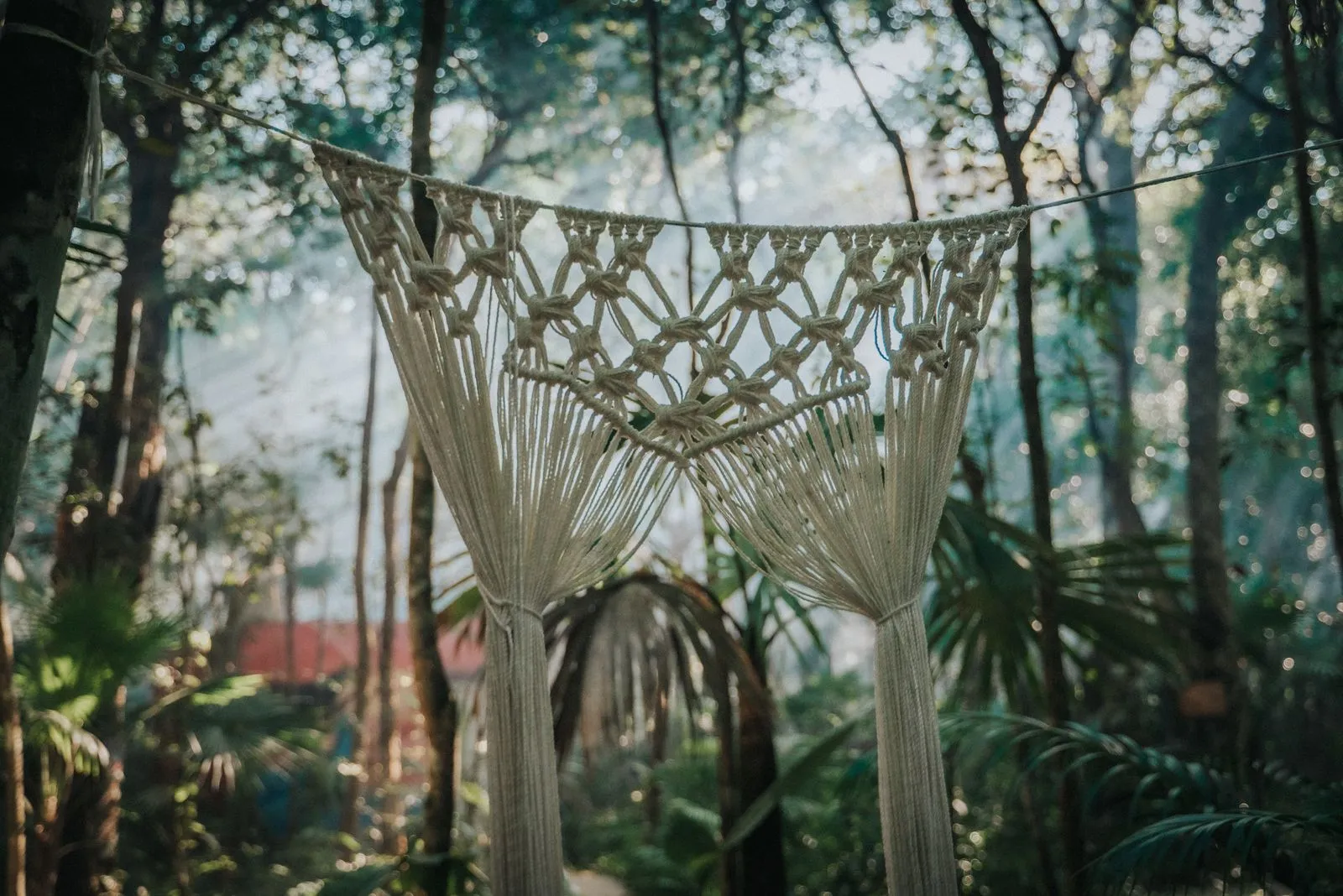 Handwoven macramé archway with geometric knotwork frames a jungle path, Lunita Jungle Retreat