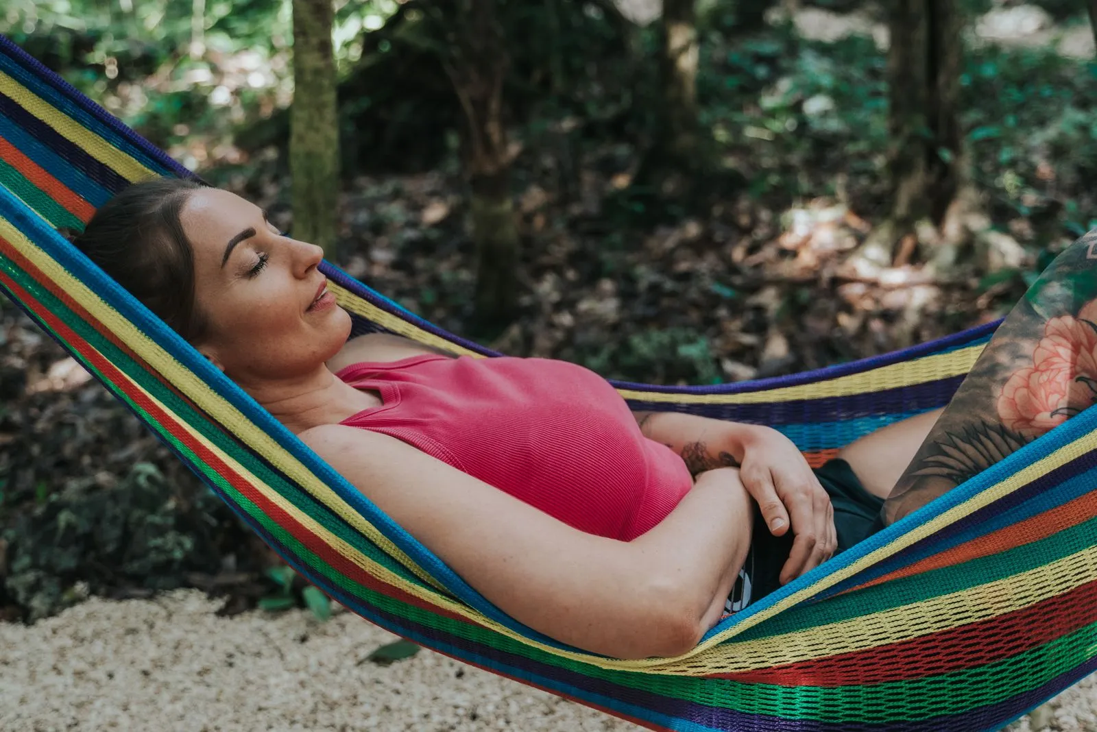 One person in a calm jungle moment, or a peaceful single hammock or reading nook, wide horizontal. Solitary but warm, not lonely